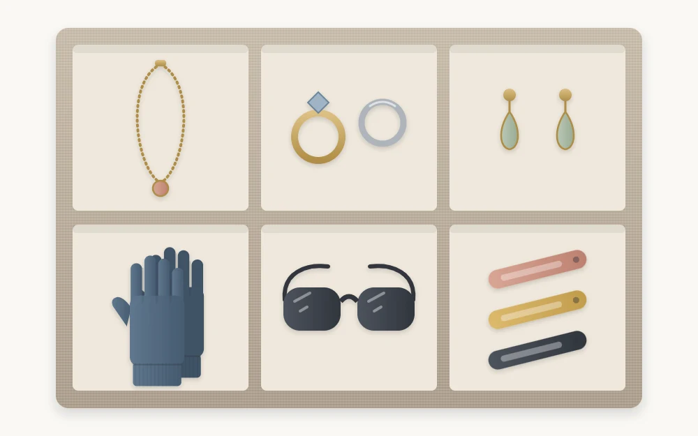 Top view of a shallow tray with six compartments holding a necklace, rings, earrings, gloves, sunglasses and hair clips